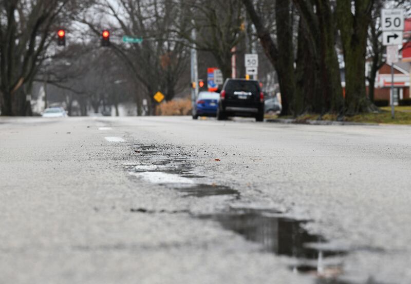 Rain puddles in the potholes along South Indiana Avenue in Kankakee in January 2023.