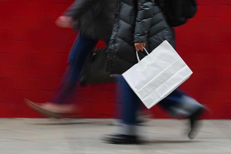 FILE - A person carries a shopping bag in Philadelphia, Wednesday, Dec. 10, 2025. (AP Photo/Matt Rourke, File)