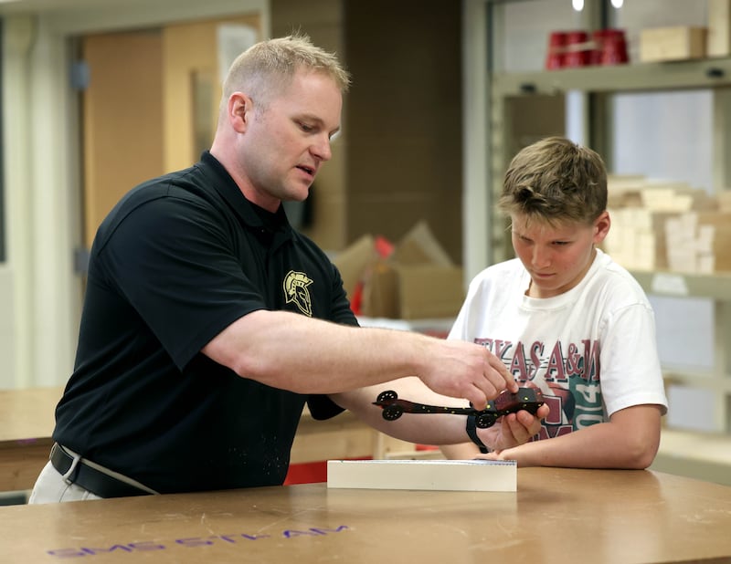 Kevin Boltz, career and technical education teacher at Sycamore Middle School, teaches sixth grader Lincoln Rissman about the CO2 dragsters Friday, April, 11, 2025, in the STEM classroom at the school.