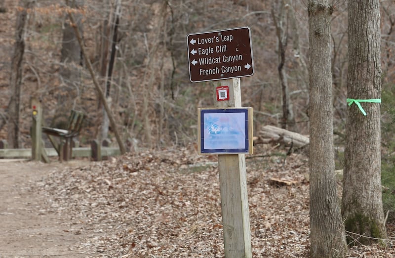 A green ribbon is attached to a tree next to a sign to the Lovers Leap, Eagle Cliff and Wildcat Canyon trailhead on Monday, March 2, 2026 at Starved Rock State Park. Starved Rock State Park received a 37 million upgrade to trail improvement that is underway and continue through 2026. Trail closures will be announced on the Starved Rock and Matthiessen State Park Facebook pages.