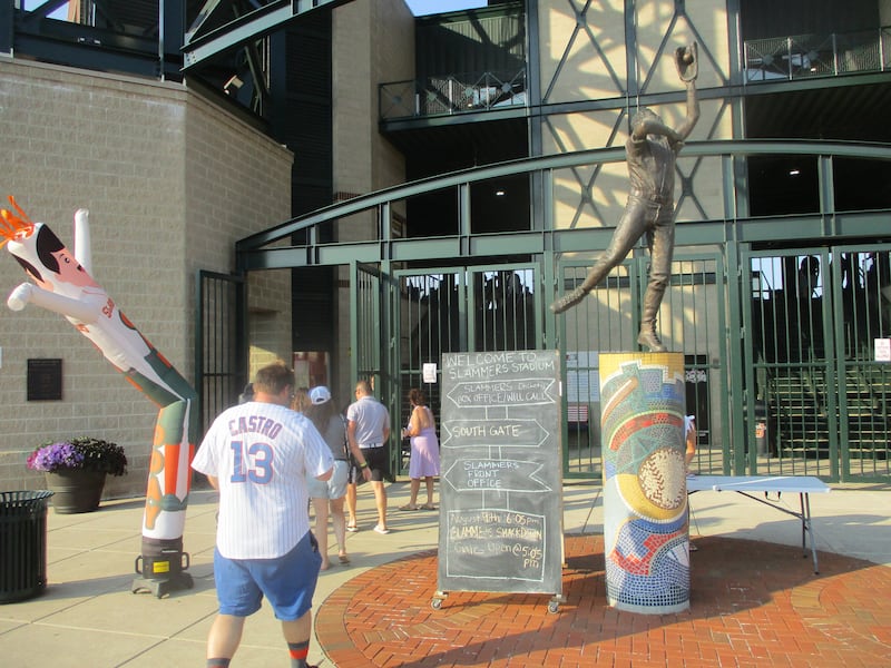 Fans walk past a statue depicting Joliet native and retired Major League Baseball outfielder Jesse Barfield before a game at Slammers Stadium in Joliet on Saturday. Aug. 9, 2025