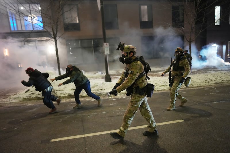 Federal agents try to clear demonstrators near a hotel, using tear gas during a noise demonstration protest in response to federal immigration enforcement operations in the city Sunday, Jan. 25, 2026, in Minneapolis. (AP Photo/Adam Gray)