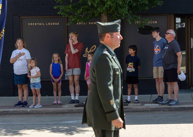 Parade watchers stand with respect as the color guard passes Monday, May 25, 2026, for Dixon’s Memorial Day observance.