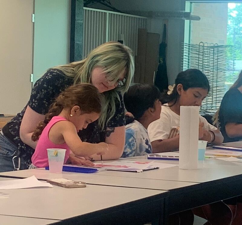 Art Teacher Pat Rutter works with children attending West Suburban Community Pantry’s summer art camp.  Art and cooking camps are free for children of families served by the food pantry.