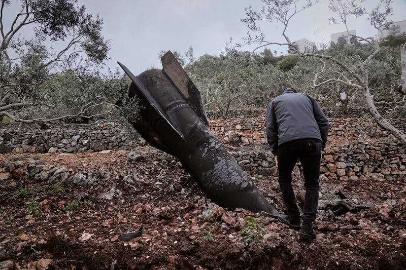 A man inspect the wreckage of an Iranian missile that landed near the West Bank village of Marda, Tuesday, March 31, 2026. (AP Photo/Majdi Mohammed)