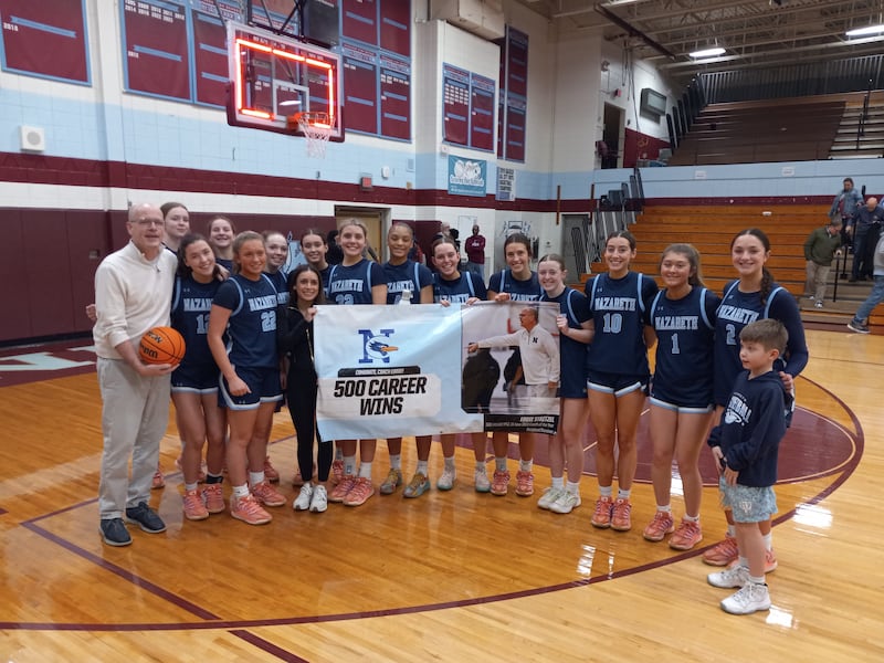 Nazareth's girls basketball team poses with head coach Eddie Stritzel (left) in celebration of his 500th career win, a 69-19 road win over Kankakee on Feb. 10, 2026.