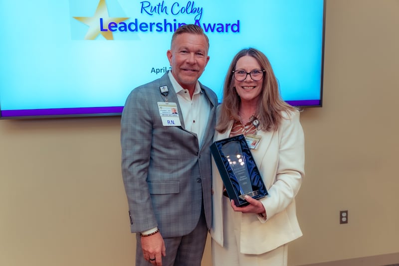 Debra Robbins, director of marketing & communications at Silver Cross Hospital in New Lenox, proudly accepts the Ruth Colby Leadership Award from Silver Cross Hospital president and chief executive officer Michael Mutterer, on Thursday, April 23, 2026, during the hospital’s monthly leadership meeting at the New Lenox hospital.