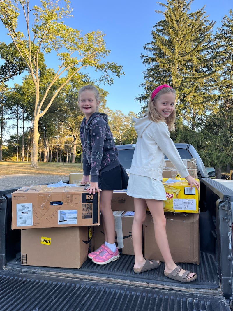 Pictured is Annabelle and Lauren Drozd, daughters of Brittany and Nate Drozd, helping load 19 boxes of donated items onto the collection semi at Zion Lutheran Church in Rockford.
