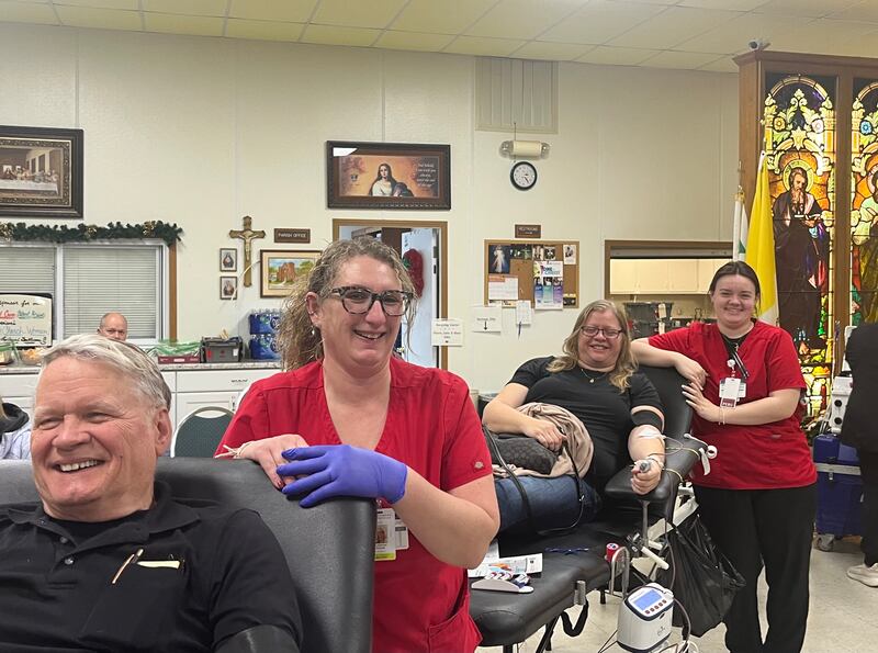 Jeffry Bramm (front) and his daughter, Lisa Bramm Rogers, give blood in Morrison while tended to by American Red Cross staff members.
