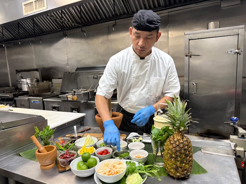 May Thai Kitchen owner and chef Anucha Namta prepares the Crystal Lake-based restaurant's green papaya salad.