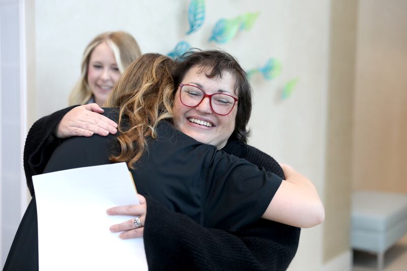 Christina Keasler of St. Charles hugs Bella DeRosa, 17, of South Elgin on Thursday, May 1, 2025 at the Northwestern Medicine Cancer Center Delnor in Geneva. Keasler is the first recipient of a gift from the Mary DeRosa Foundation, a charity founded by Mary’s widower, Guy DeRosa, and his children to support others with cancer. Mary DeRosa of South Elgin died of metastatic triple-negative breast cancer in 2022.