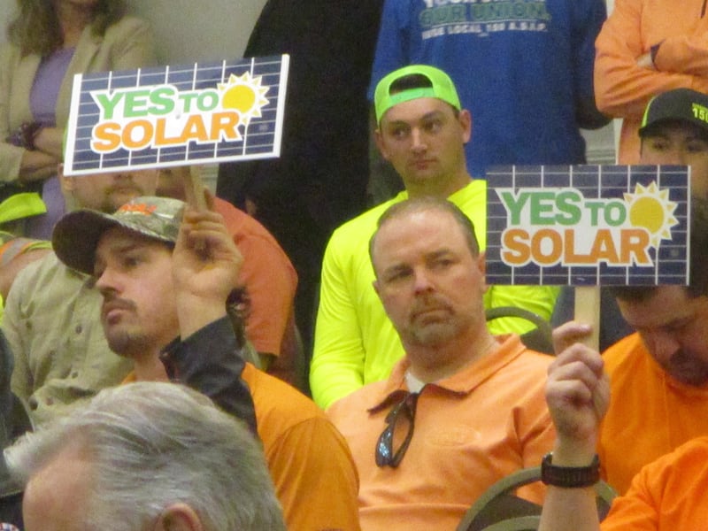 Union construction workers hold up signs in support of solar energy projects Thursday during a Will County Board meeting in Joliet. April 16, 2026