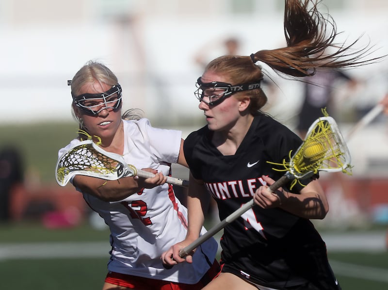 Barrington's Iris Stennett tries to stop Huntley's Mya Holmberg as she runs toward the goal during the Huntley Supersectional girls lacrosse match on Tuesday, June 2, 2026, at Huntley High School.