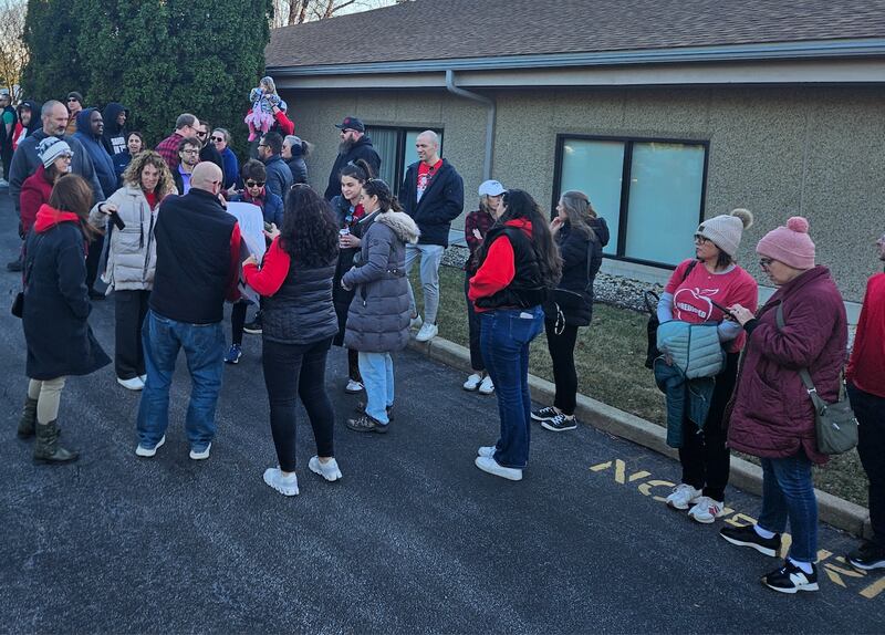 Community High School District 99 faculty and parents gather outside the district's Administrative Service Center Monday to support the district's custodial, maintenance and ground staff.