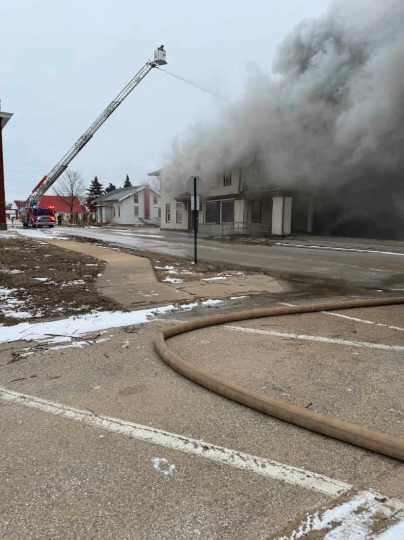 Firefighters spray water on a burning apartment building Sunday in Fulton.
