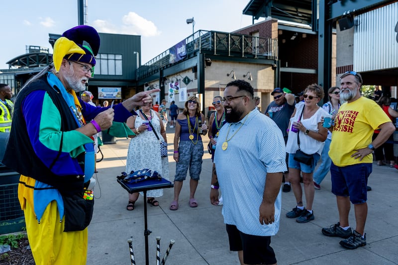 Keith Cobb performs a card trick for Joliet resident Eddie Perez during New Orleans North Festival at Joliet Slammers Stadium on Aug. 15, 2025.
