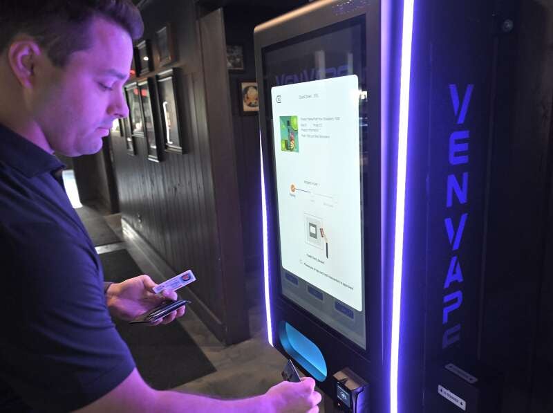 John Floro, co-owner of Elmhurst-based VenVape, demonstrates one of the company's vape vending machines at Local Bar & Grille in Wood Dale. The machine scans driver’s licenses before allowing a credit card purchase.