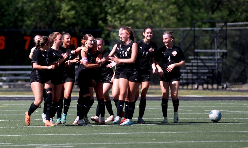 Wheaton Warrenville South players celebrate a goal by Ashlyn Adams (center) during a game against St. Charles East on Friday, May 16, 2025 in Wheaton.