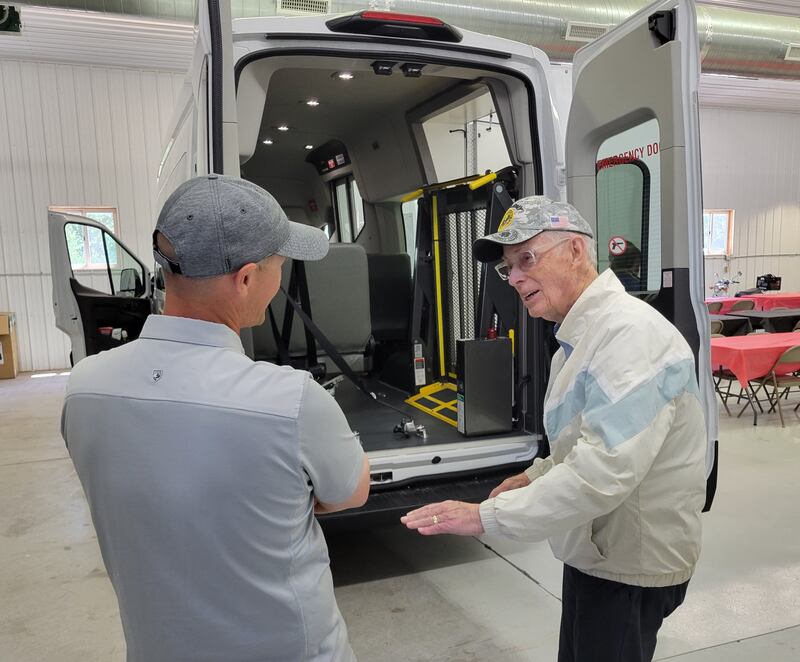 La Salle County Board member Tom Walsh (right) chats about the four new NCAT buses during Tuesday afternoon's unveiling in Ottawa.