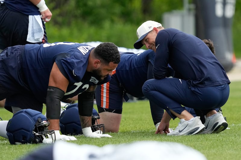 Chicago Bears head coach Ben Johnson, right, smiles as he talks with offensive tackle Kiran Amegadjie during the NFL football team's practice in Lake Forest, Ill., Tuesday, June 9, 2026. (AP Photo/Nam Y. Huh)