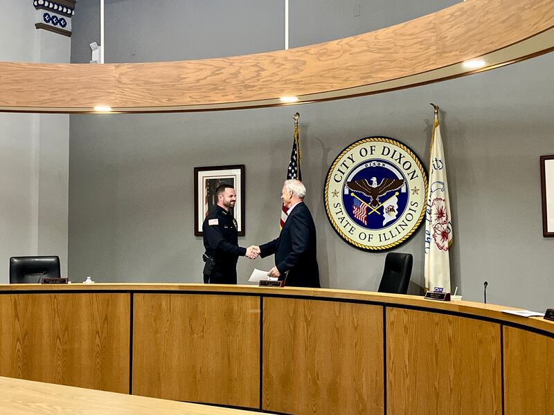 Dixon's new chief of police Ryan Bivins (left) shakes hands with Dixon Mayor Glen Hughes (right) after taking the oath of office at Monday's city council meeting, June 2, 2025.