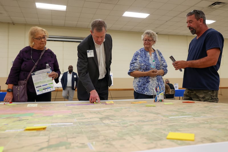 Monee resident Terri Hall, left, and Peotone resident Lynn Temme, right of center, discuss ideas with Illinois Department of Transportation design consultant John Nelson during IDOT's public meeting at the Will County Fair atrium on Aug. 26, 2025.