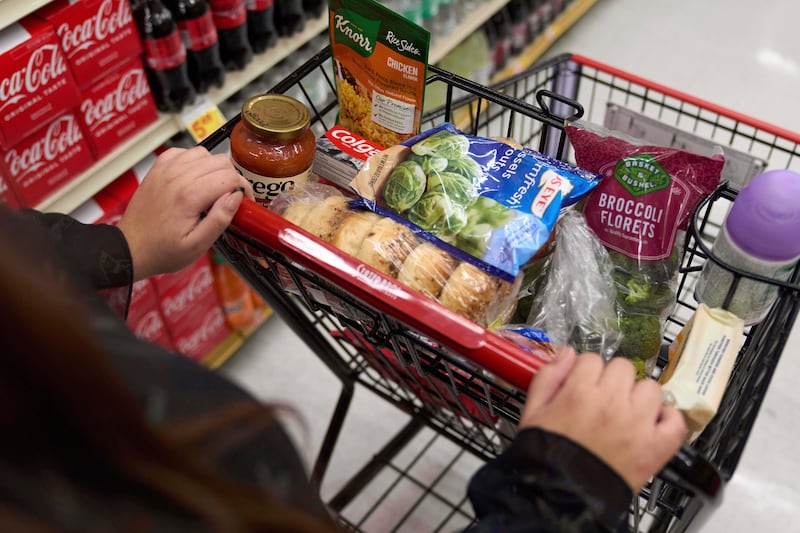 FILE - A California's SNAP benefits shopper pushes a cart through a supermarket in Bellflower, Calif., Feb. 13, 2023. (AP Photo/Allison Dinner, File)