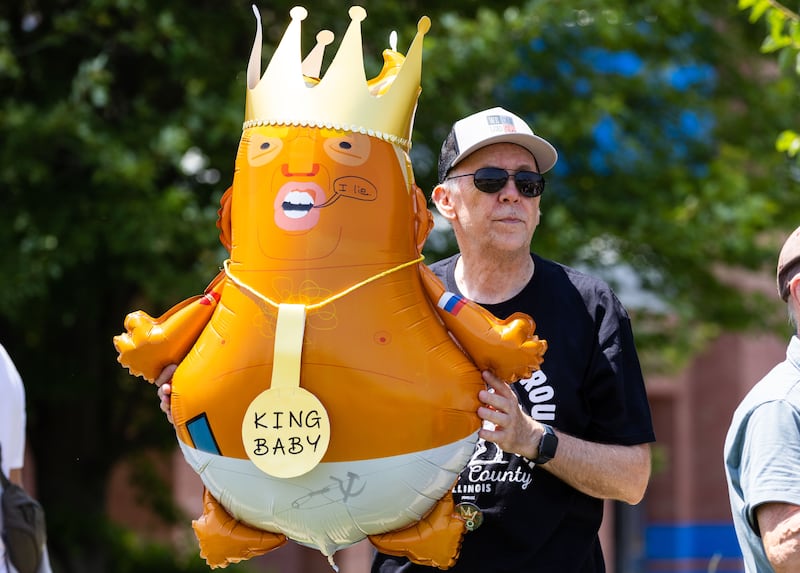 James Flanigan of St. Charles holds a balloon during a “No Kings Day” Protest against President Donald Trump’s policies along South Randall Road in Geneva on Saturday, June 14, 2025.