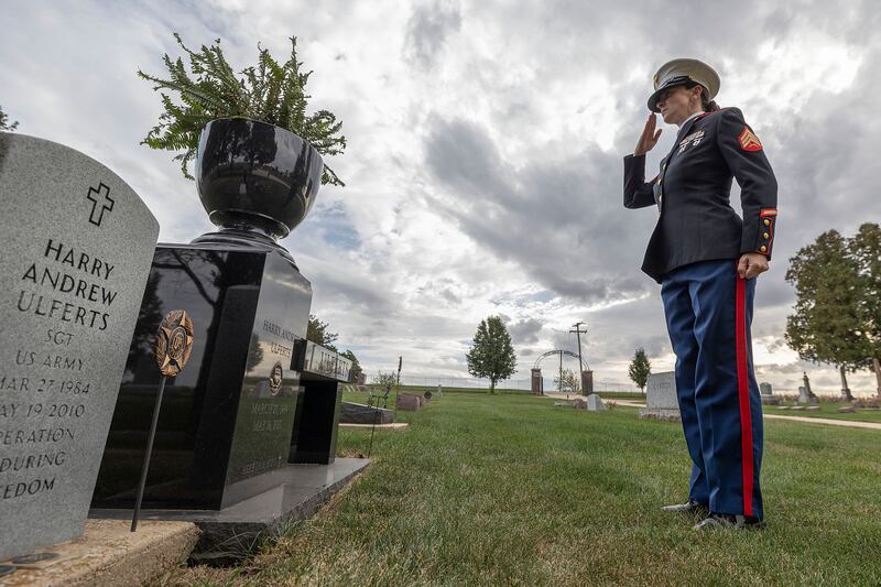 Elise Ulferts-Hume salutes her brother’s grave at Palmyra Cemetery Tuesday, Oct, 7, 2025. Ulferts joined the Marines to honor her Army veteran brother, Harry Andrew Ulferts, who died in a car accident in 2010.