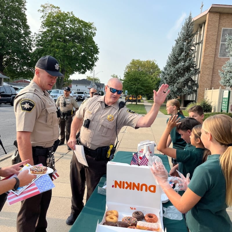 Bishop McNamara Catholic School students high five Kankakee County Sheriff's Department officers during the 2024 Gratitude Drive-Thru honoring first responders, active-duty service members and veterans.