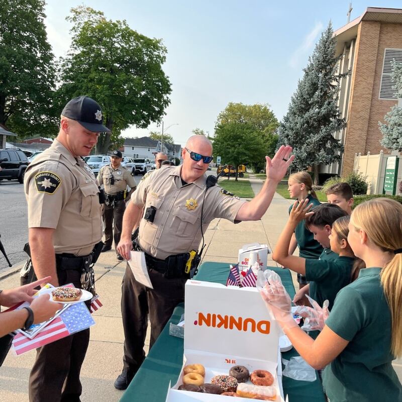 Bishop McNamara Catholic School students high five Kankakee County Sheriff's Department officers during the 2024 Gratitude Drive-Thru honoring first responders, active-duty service members and veterans.