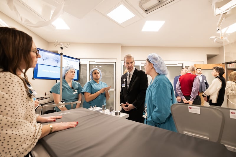 Phil Kambic, president and CEO of Riverside Healthcare, along with Riverside medical staff, talk with Krystal Hiser, Riverside’s director of perioperative and interventional services, about Riverside’s new Neurointerventional Biplane Imaging Suite during an open house event.