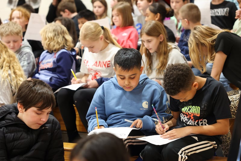 St. Anne Grade School students tally up the high school scrimmage basketball game score on their math worksheets during the district's Math Madness held on March 20 at the high school.