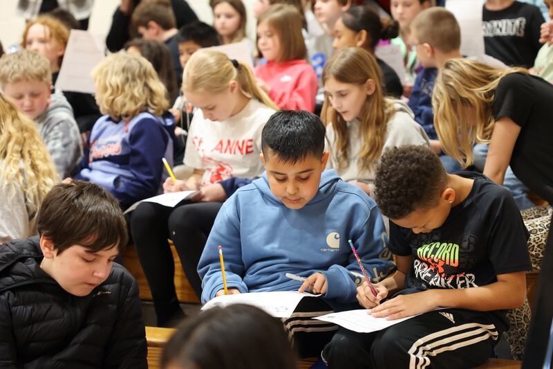 St. Anne Grade School students tally up the high school scrimmage basketball game score on their math worksheets during the district's Math Madness held on March 20 at the high school.