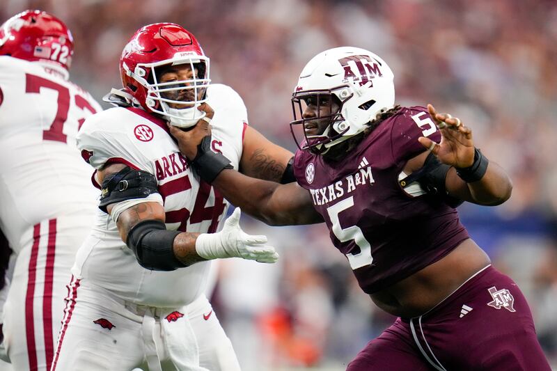 Texas A&M defensive lineman Shemar Turner (5) attacks against Arkansas offensive lineman Keyshawn Blackstock during the first half of an NCAA college football game between Texas A&M and Arkansas, Saturday, Sept. 28, 2024, in Arlington, Texas. Texas A&M won 21-17. (AP Photo/Julio Cortez)