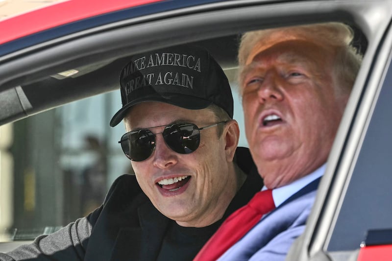 President Donald Trump and Tesla CEO Elon Musk speak to reporters as they sit in a Tesla vehicle on the South Lawn of the White House on March 11 in Washington.