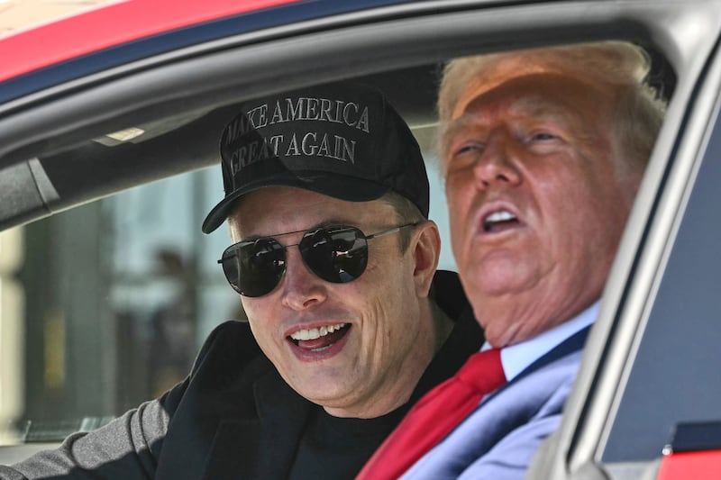 President Donald Trump and Tesla CEO Elon Musk speak to reporters as they sit in a Tesla vehicle on the South Lawn of the White House on March 11 in Washington.