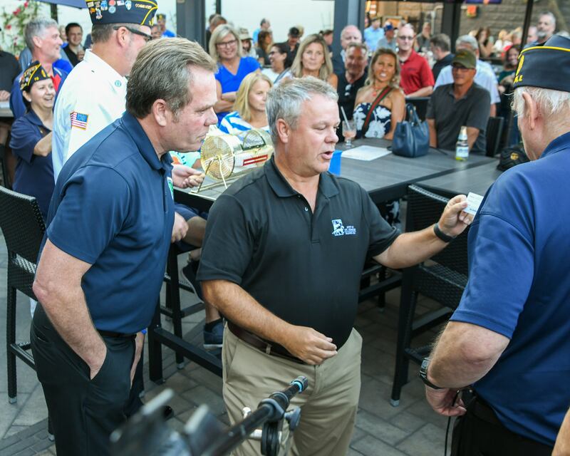 Geneva Mayor Kevin Burns (left) and St. Charles Mayor Clint Hull read the winning ticket at an American Legion fundraiser Thursday Aug. 21, 2025, held at Whiskey Bend in St. Charles.