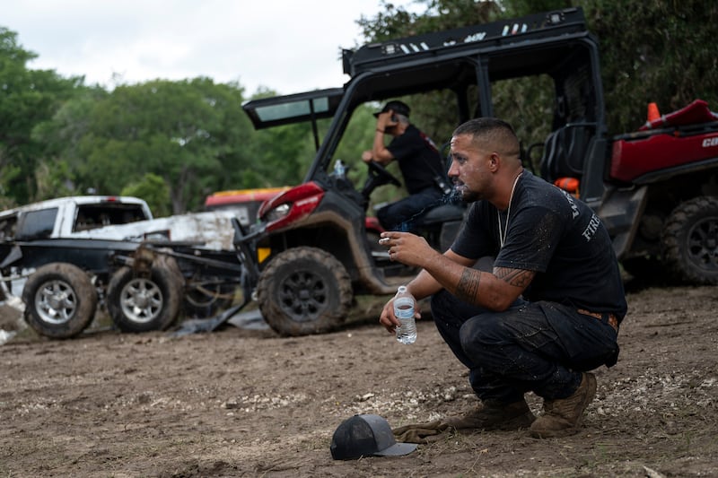 West Odessa Volunteer Firefighter Jed Wolske takes a smoke break while aiding in search and rescue efforts along the Guadalupe River, days after a flash flood swept through the area, Monday, July 7, 2025, in Ingram, Texas. (AP Photo/Eli Hartman)