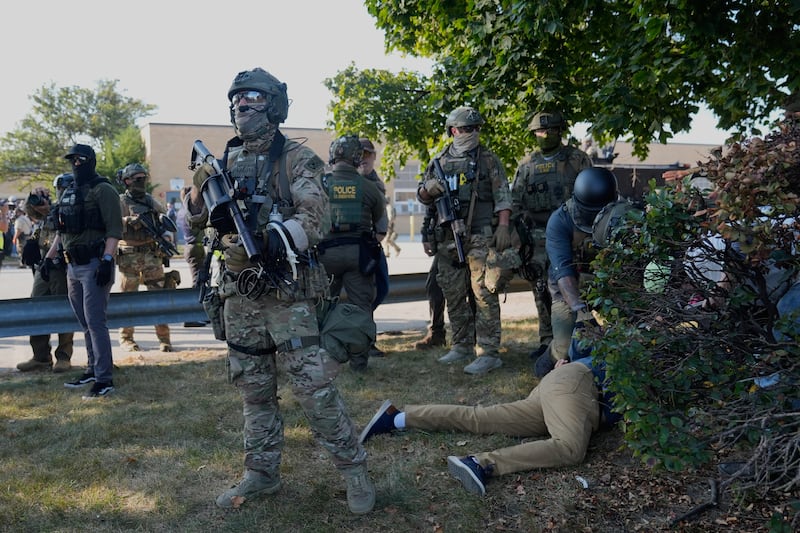 Law enforcement detains a protester near an Immigration and Customs Enforcement facility in Broadview, Ill., Friday, Oct. 3, 2025. (AP Photo/Erin Hooley)