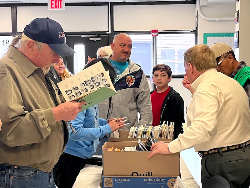 Attendees look through old yearbooks on Saturday, April 18, 2026, at Gompers Junior High School in Joliet.