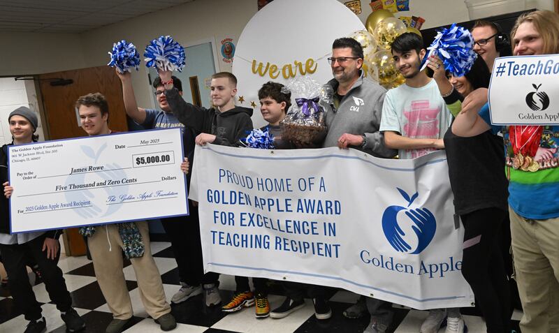 Clare Woods Academy science teacher James Rowe celebrates with some of his students after winning the Golden Apple Award for Excellence in Teaching Monday morning in Wheaton.