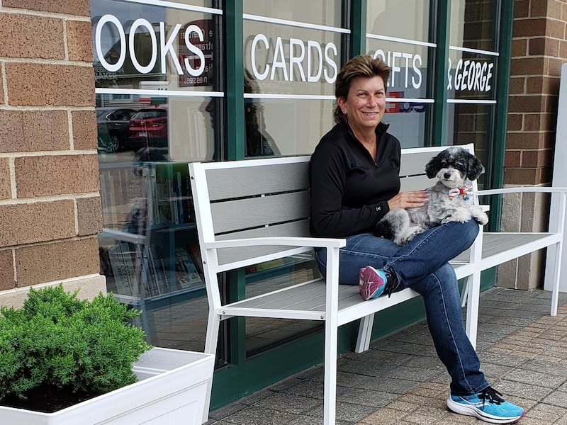 Diane Steverson, owner of Abalabix Book, sits outside the bookstore in downtown Crystal Lake with dog George.