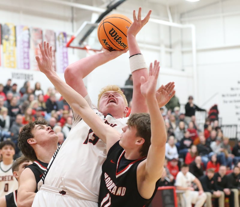 Indian Creek's Isaac Willis eyes the hoop as Woodland's Brezdyn Simons and teammate Nate Berry defend during the Class 1A Sectional Semifinal game on Wednesday, March 4, 2026 at Amboy High School.
