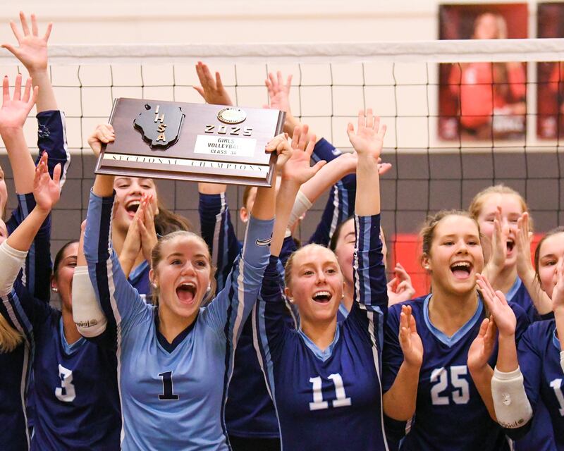 Nazareth Academy teammates Gianna Torrejon (3), Tess Tortorello (1), Gia Petrecca (11) and Ellie Warren (25) all celebrate with their teammates after winning the sectional title game over Geneva on Thursday Nov. 6, 2025, held at Timothy Christian High School.