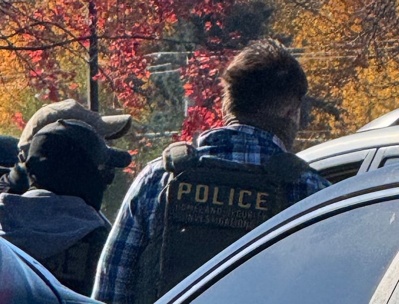Agents wearing masks and vests that say Homeland Security take a man into custody outside the McHenry County courthouse in Woodstock on Wednesday, Nov. 5, 2025. Eye witnesses said the officers smashed the driver's side window of a car to detain the man.