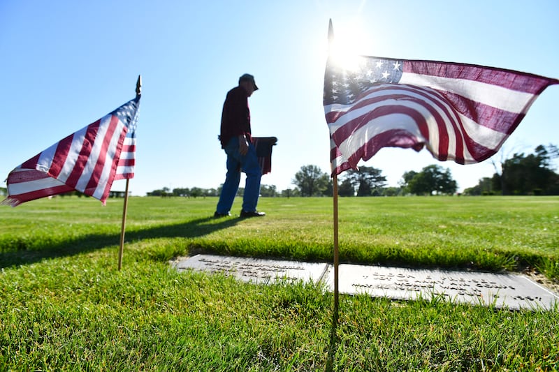Vietnam army veteran Tom Sovinski, a Kankakee resident and member of the 1st Cavalry Division, walks the rows of headstones at Kankakee Memorial Gardens placing flags at veterans' graves on ahead of the 2023 Memorial Day weekend. The annual tradition is completed by volunteers with the Kankakee County Veterans Council over the course of two days across three local cemeteries.