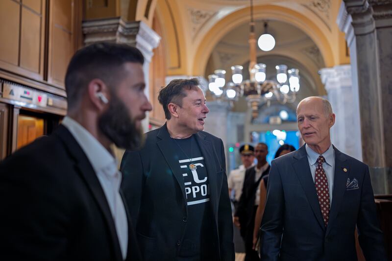 Elon Musk, center left, operating with a directive from President Donald Trump to slash government spending, walks with Sen. Rick Scott, R-Fla., right, as he arrives to meet with Republican senators, at the Capitol, in Washington, Wednesday, March 5, 2025. (AP Photo/J. Scott Applewhite)
