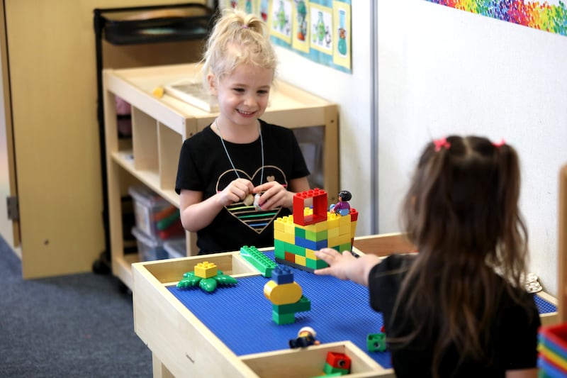 Students Ella and Mika play with Legos at the Fox Valley YMCA Central Branch’s Early Learning Academy in Plano.