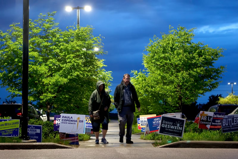 People walk through signs in front of a vote center during a primary election on Tuesday, May 5, 2026, in West Lafayette, Ind. (AP Photo/Cara Penquite)